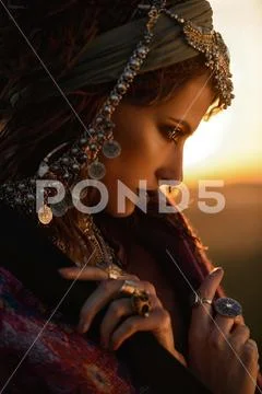 Beautiful fashion model posing in boho style clothes in the rays of the sunse Stock Photos