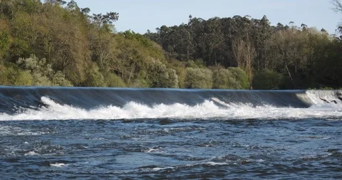 Beautiful fast flowing river in spring with water gushing over weir Stock Footage 127134999