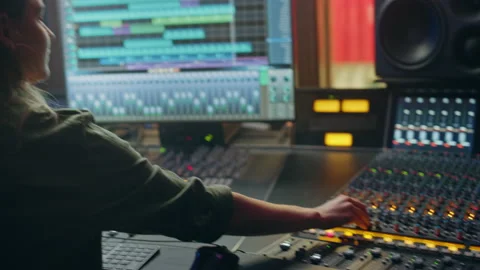 Beautiful Female Audio Engineer Working in Recording Studio, Uses Mixing Board Stock Footage 130698442