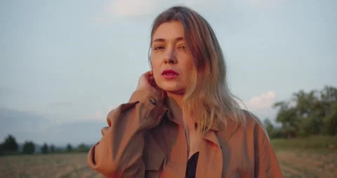 Beautiful female blonde model standing on a plowed field Stock Footage 221461953