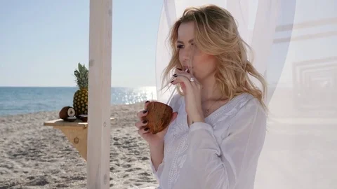 Beautiful female in bungalow, waving white cloth, girl drink cocktail Stock Footage