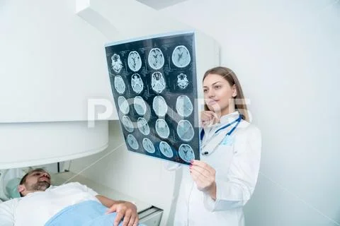 Beautiful female doctor visiting male patient who is in bed. Stock Photos