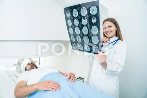 Beautiful female doctor visiting male patient who is in bed. Stock Photos