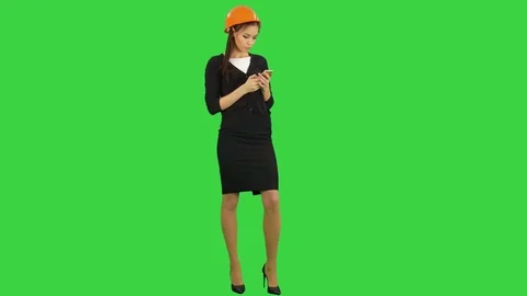 Beautiful female engineer in hardhat using a cellphone on a Green Screen, Chroma Stock Footage 71755162