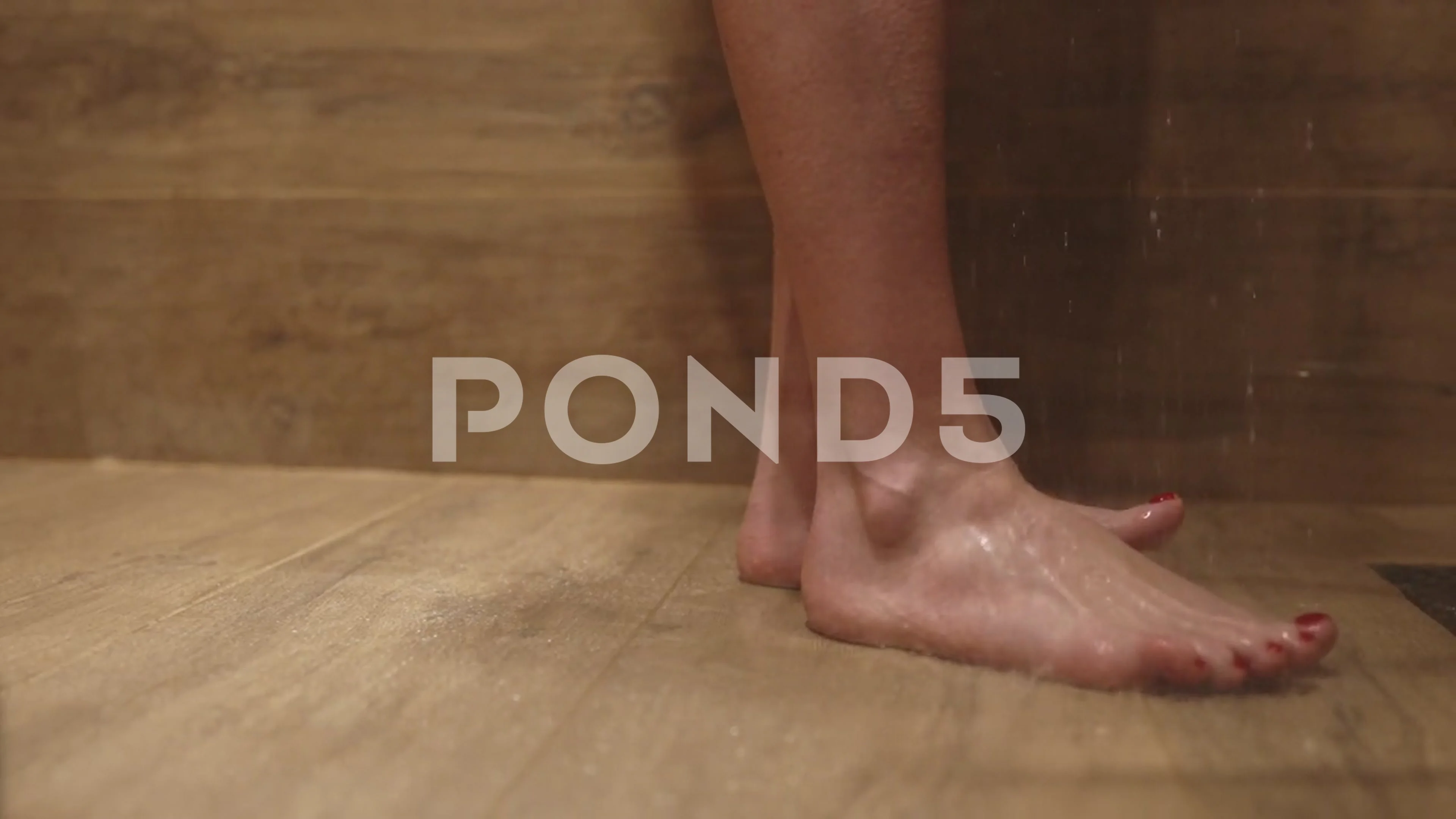 Beautiful female feet under the shower. Close up woman feet, drops of water