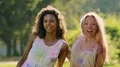Beautiful female friends covered in colorful paint hugging, smiling to camera HD Footage
