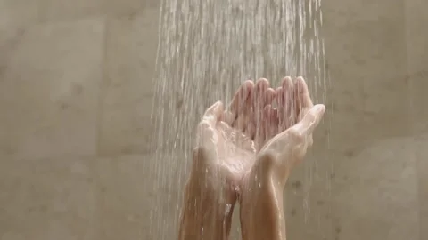 Beautiful female hands under the streams of water in the shower. Slow motion. Stock Footage