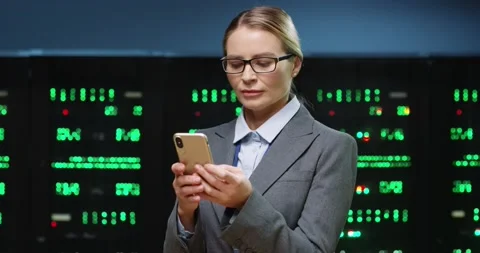 Beautiful female IT programmer with glasses stands in server room holding Stock Footage 152056305