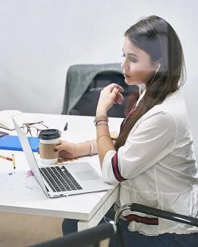 Beautiful female junior developer or manager working on laptop in IT office Stock Photos