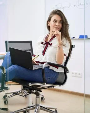 Beautiful female junior software developer working on laptop in IT office Foto stock