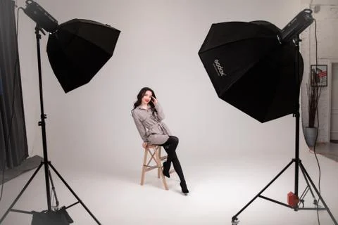 Beautiful female model posing at studio in the light flashes Stock Photos
