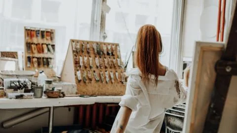 Beautiful female painter dancing while painting in art workshop Stock Photos