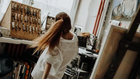 Beautiful female painter dancing while painting in art workshop Stock Photos