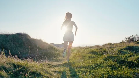 Beautiful female running or jogging Working out in natural ocean cliff sunrise Stock Footage