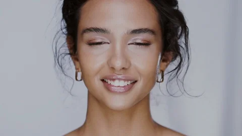 Beautiful female using face oil with pipette and moisturizing her cheeks Video stock 123725497