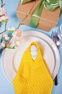 Beautiful festive Easter table setting with yellow napkin polka dot and smili Stock Photos