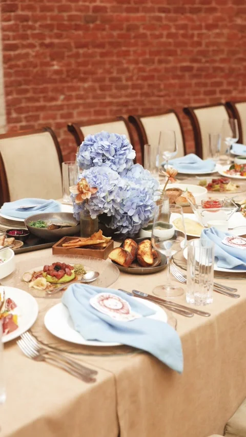 Beautiful festive table setting with blue hydrangea centerpiece and elegant Stock Footage 320374399