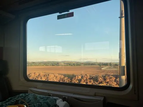 Beautiful fields on sunset in the window of a moving train Stock Photos