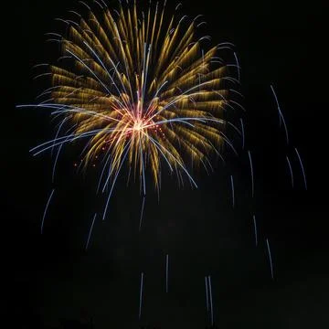 Beautiful fiery rays of light from explosion of pyrotechnics on black background Foto stock