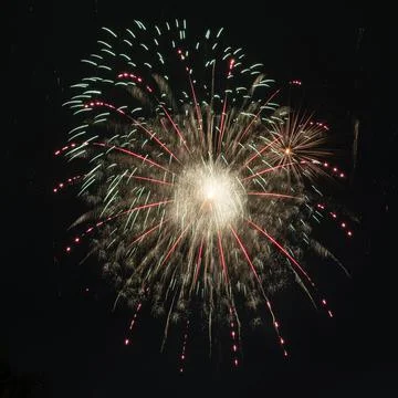 Beautiful fiery rays of light from explosion of pyrotechnics on black background Foto stock