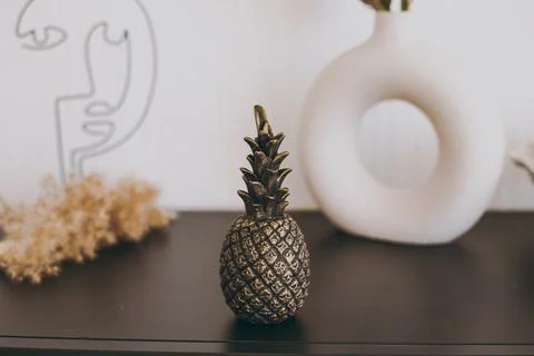 A beautiful figurine of a small black pineapple stands on the table as decor Stock Photos