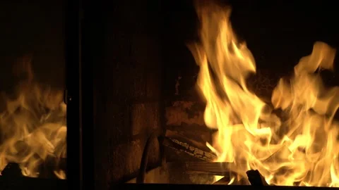 A beautiful fire in the home fireplace is reflected in the glass door. Symbol Video stock 123913428