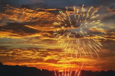 Beautiful firework display for celebration on the dramatic sunset sky. Stock Photos