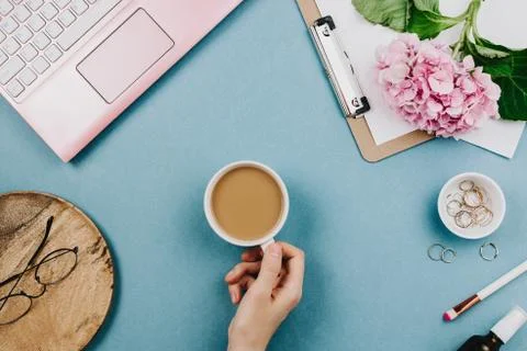 Beautiful flatlay arrangement of woman's work desk with pink laptop, cardboar Stock-Fotos