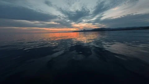 A beautiful flight low over the water in which clouds and the sunlight of the Stock Footage 288637583