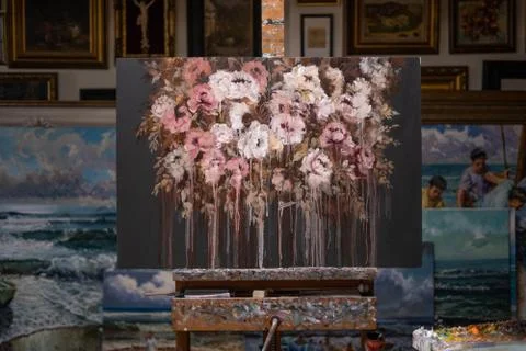 Beautiful floral painting on canvas placed on easel at workplace in creative  Stock Photos