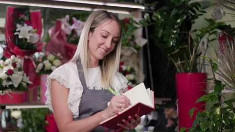 Beautiful Flower Shop Worker Checking Flowers And Holding Clipboard Stock Footage 201866513