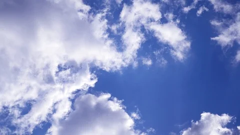 Beautiful fluffy clouds are backlit by the sun on a blue sky. 4k, 3840x2160, HD Stock Footage