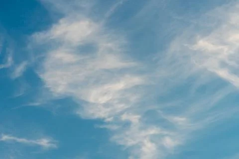 Beautiful fluffy clouds in the evening sky. The sunlight gives a side light o Stock Photos