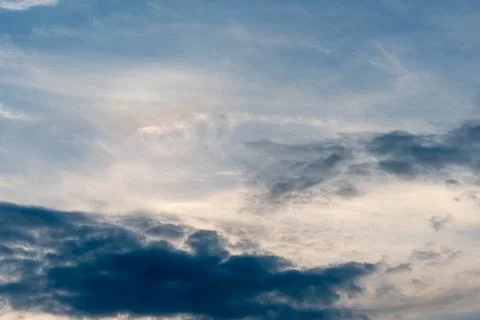 Beautiful fluffy clouds in the evening sky. The sunlight gives a side light o Stock Photos