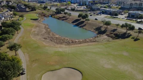 Beautiful Flyover Golf course with Pond near road in urban area Stock Footage 325808183