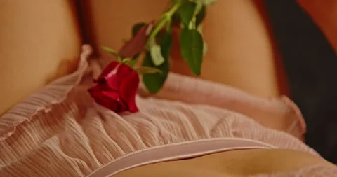 Beautiful focus rack of a red rose gently caressing the lower body of a Stock Footage 279529304