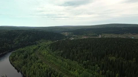 A beautiful forest river flows among the hills. In the distance you can see the  Stock Footage 154619240