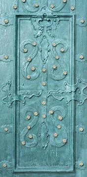 Beautiful forged patterns on an emerald-colored door. Close-up 스톡 사진