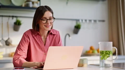 Beautiful freelancer working laptop at kitchen closeup. Woman looking computer Video stock 335104281