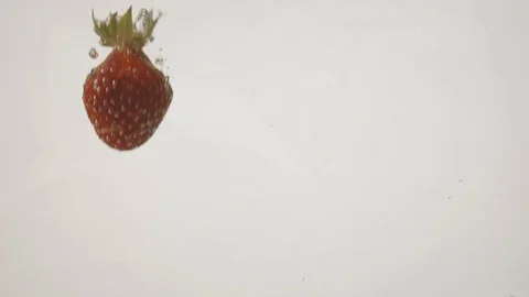Beautiful fresh strawberries falling into water in super slow motion 120fps Stock Footage 112216028