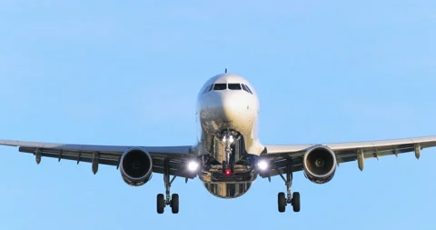 Beautiful front view of a white plane on the approach, against the background of Stock Footage 130359135