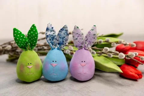 Beautiful funny multicoloured Easter fabric bunnies on grey. 스톡 사진