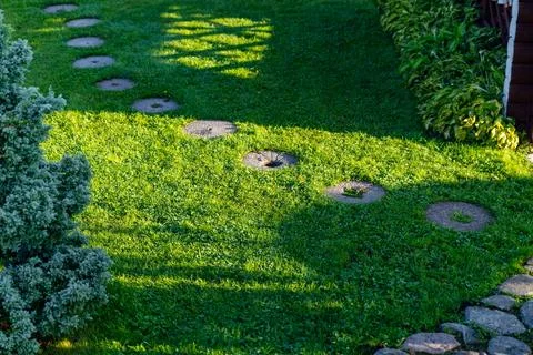 Beautiful garden path made of irregular, natural stones. The path winds thr.. Stock Photos