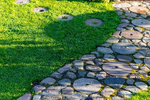 Beautiful garden path made of irregular, natural stones. The path winds thr.. Stock Photos