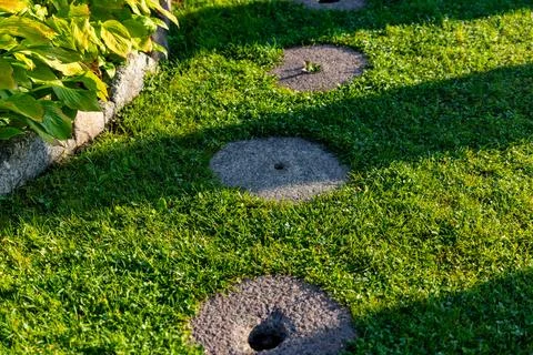 Beautiful garden path made of irregular, natural stones. The path winds throu Stock Photos