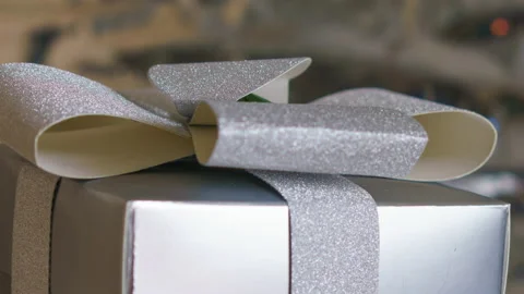 A beautiful gift box with a silver bow on a sparkling silver background. Stock Footage 159661910