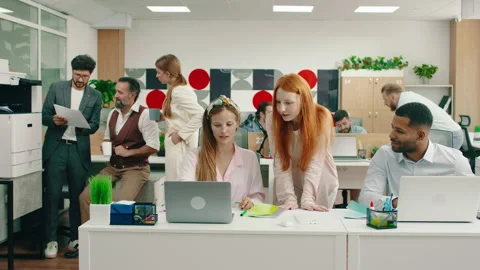 A beautiful ginger haired manager is checking up on her assistants work on their Stock Footage 166908027
