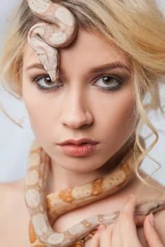 Beautiful girl and a python, which wraps around her body Stock Photos
