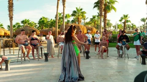 Beautiful girl belly dancing in front of tourists on the beach. Stock Footage 329058151