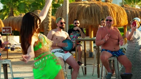 Beautiful girl belly dancing in front of tourists on the beach. Stock Footage 329058154